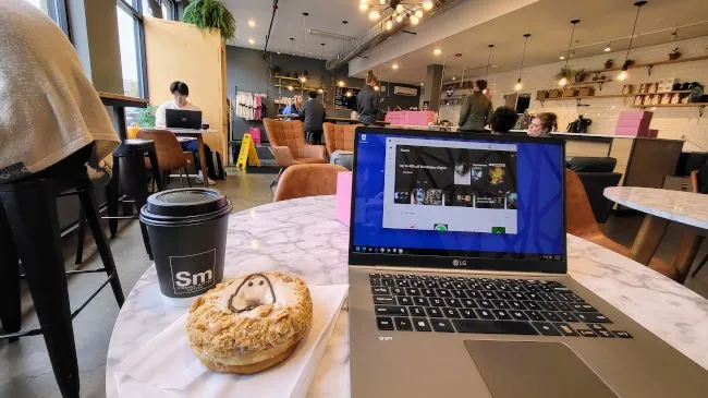 Người dùng làm việc với laptop tại quán cà phê