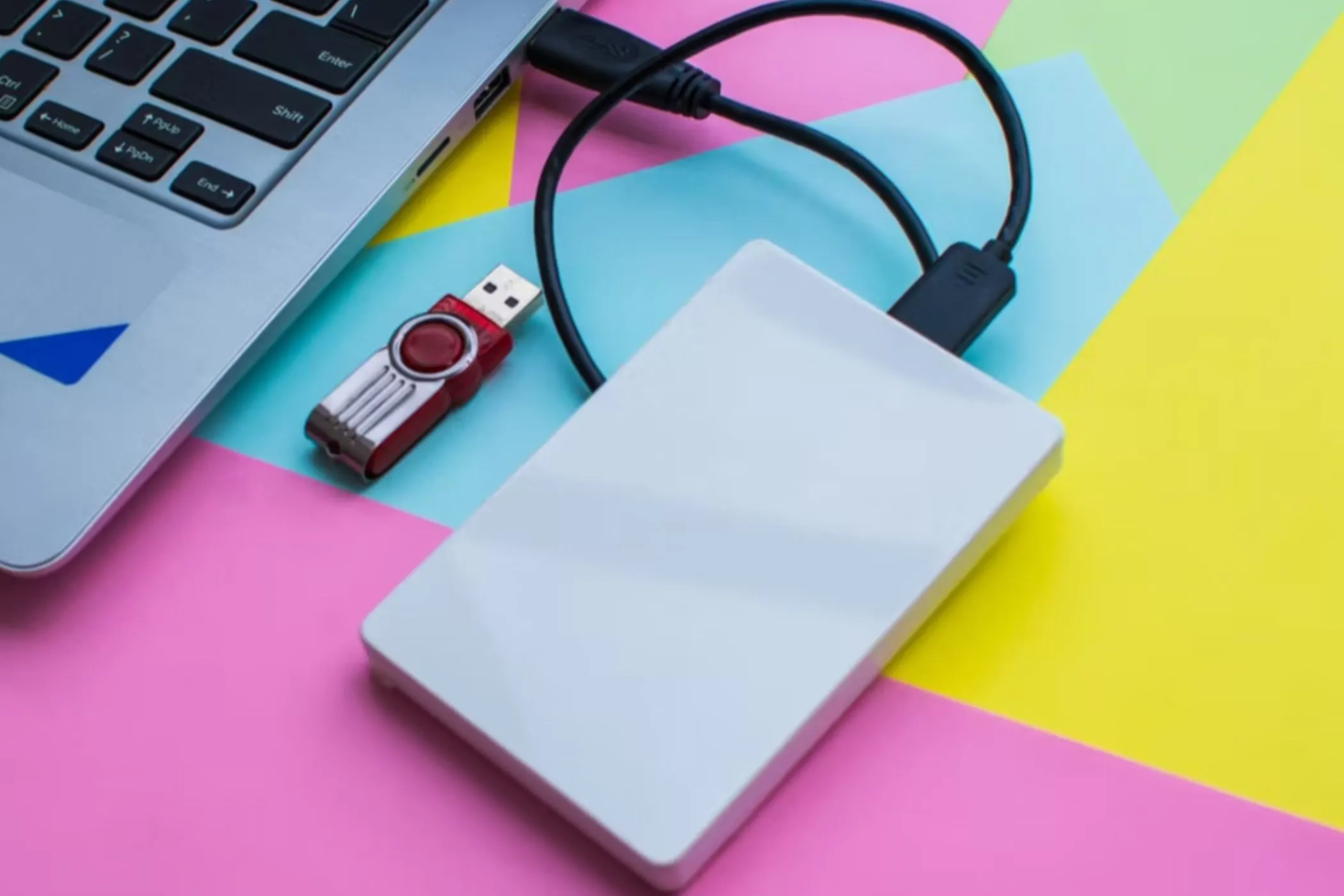 Ổ đĩa flash và ổ cứng ngoài được kết nối với laptop, minh họa việc chuyển dữ liệu an toàn.