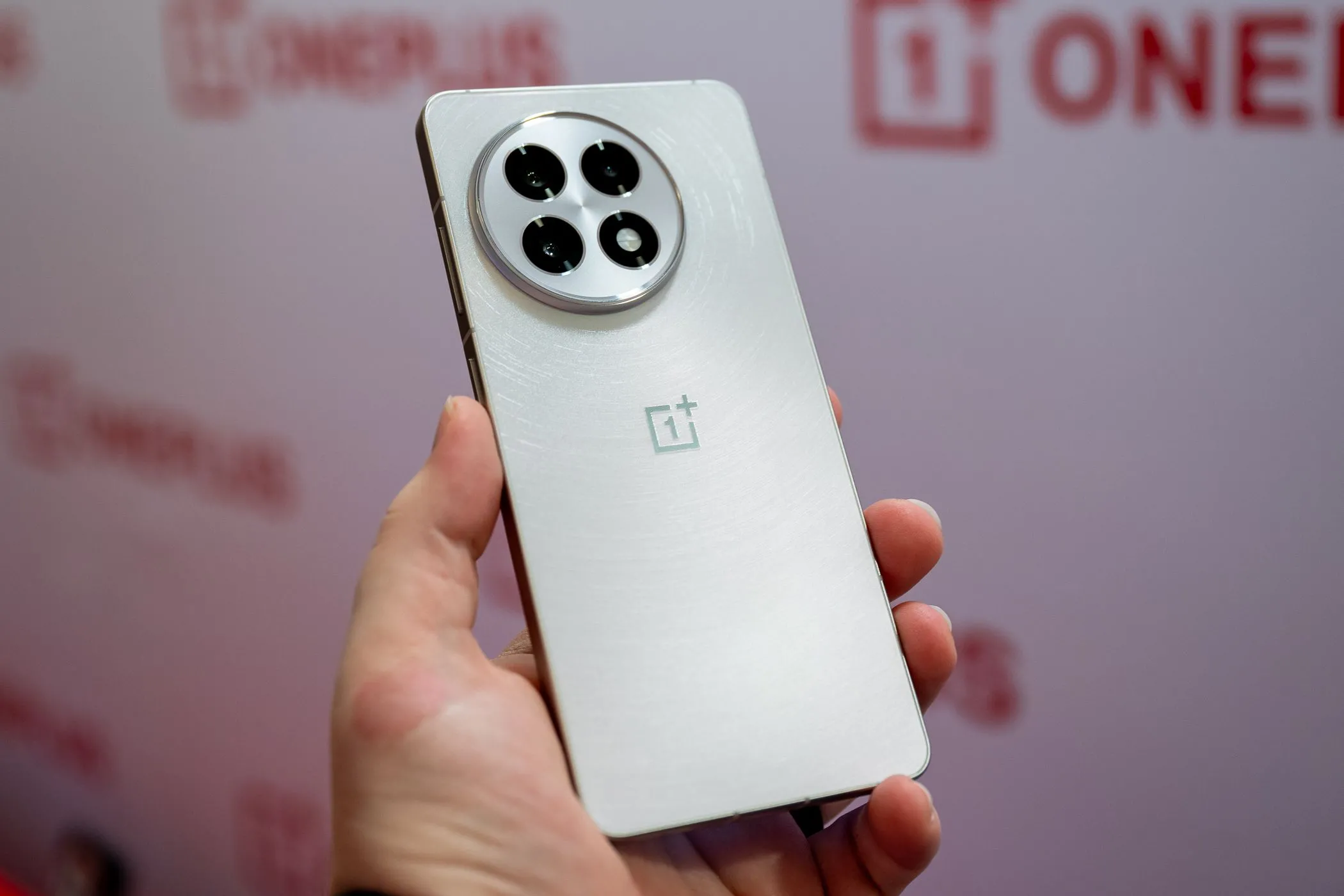 OnePlus 13R màu trắng đang được cầm trên tay, nổi bật với thiết kế cao cấp