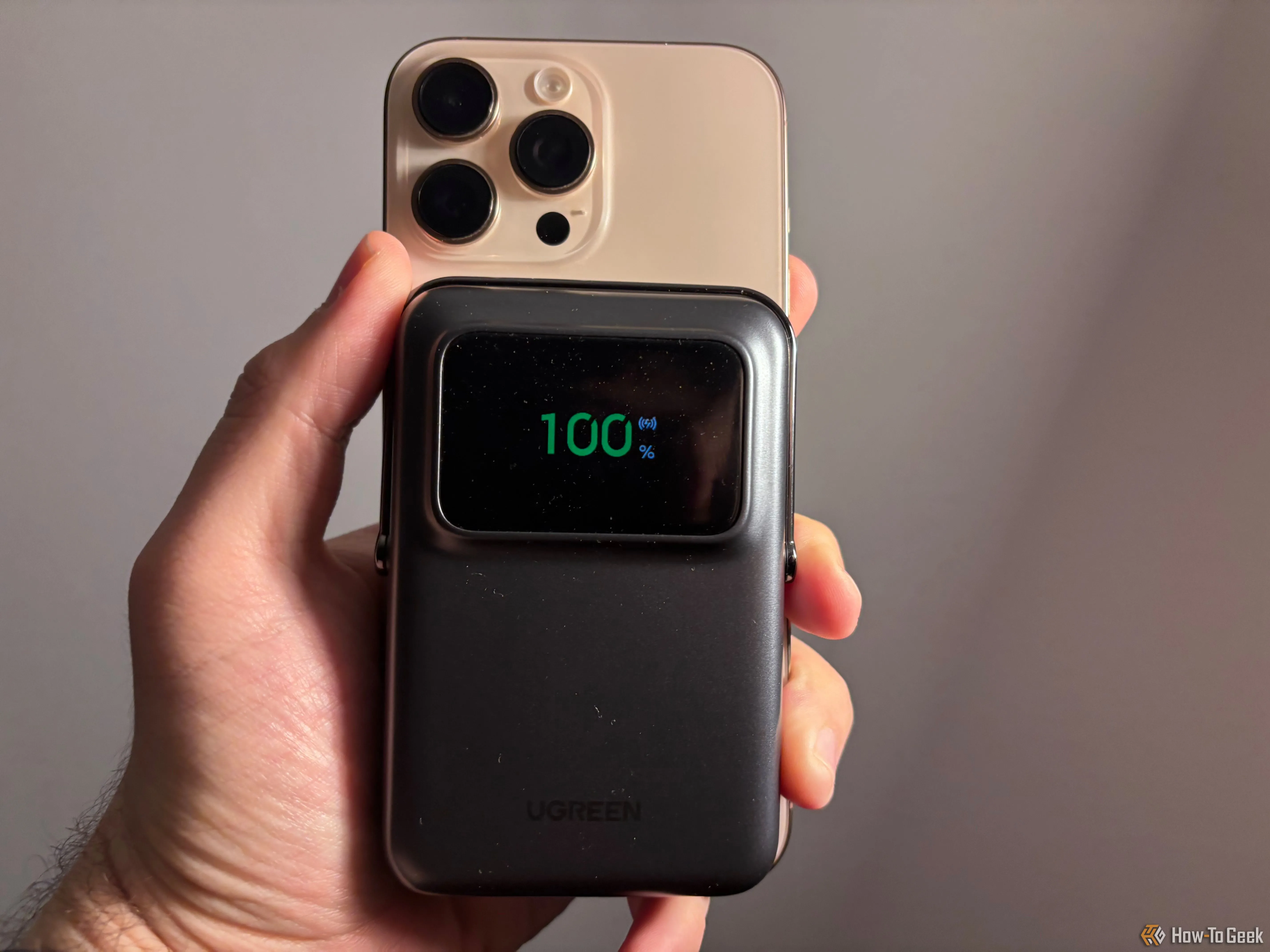 Pin sạc Ugreen Uno gắn từ tính vào iPhone 16 Pro Max, hiển thị phần trăm pin còn lại trên màn hình.