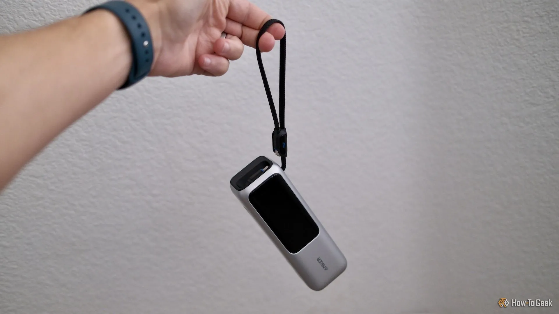 Sạc dự phòng Anker Power Bank 25K được cầm bằng dây đeo tích hợp, minh họa tính di động và tiện lợi