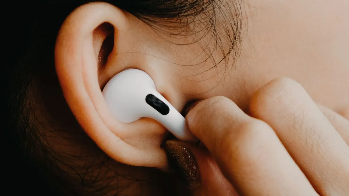 Tai nghe Apple AirPods Pro được đeo trên tai một người phụ nữ, tượng trưng cho trải nghiệm sử dụng AirPods, đặc biệt là trên hệ sinh thái Apple.