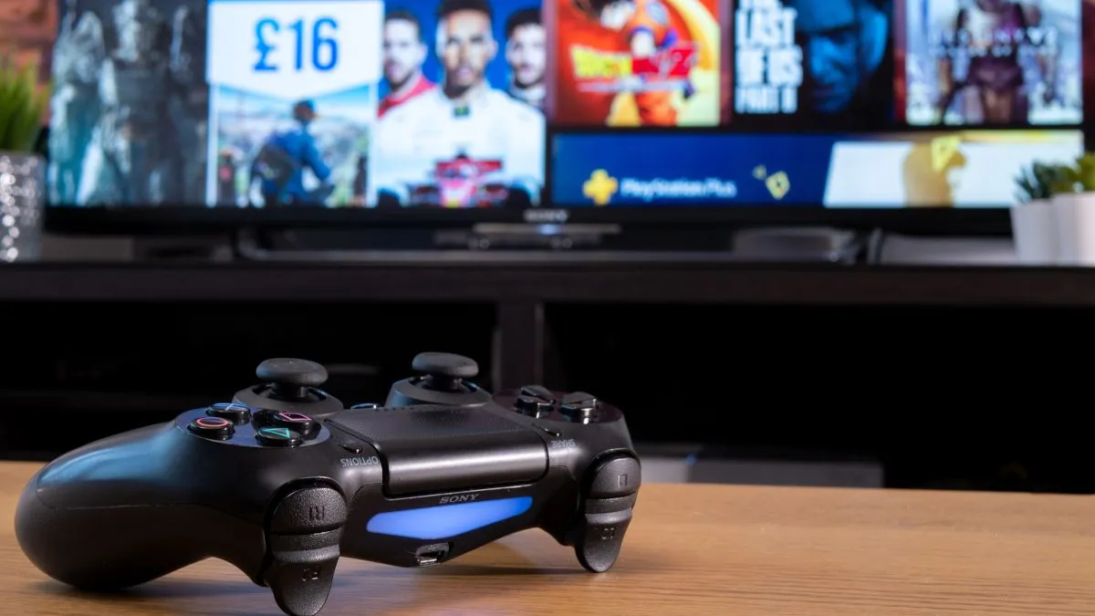 Tay cầm Sony Dualshock 4 đặt trước màn hình TV hiển thị giao diện PlayStation Store, minh họa việc mua game kỹ thuật số