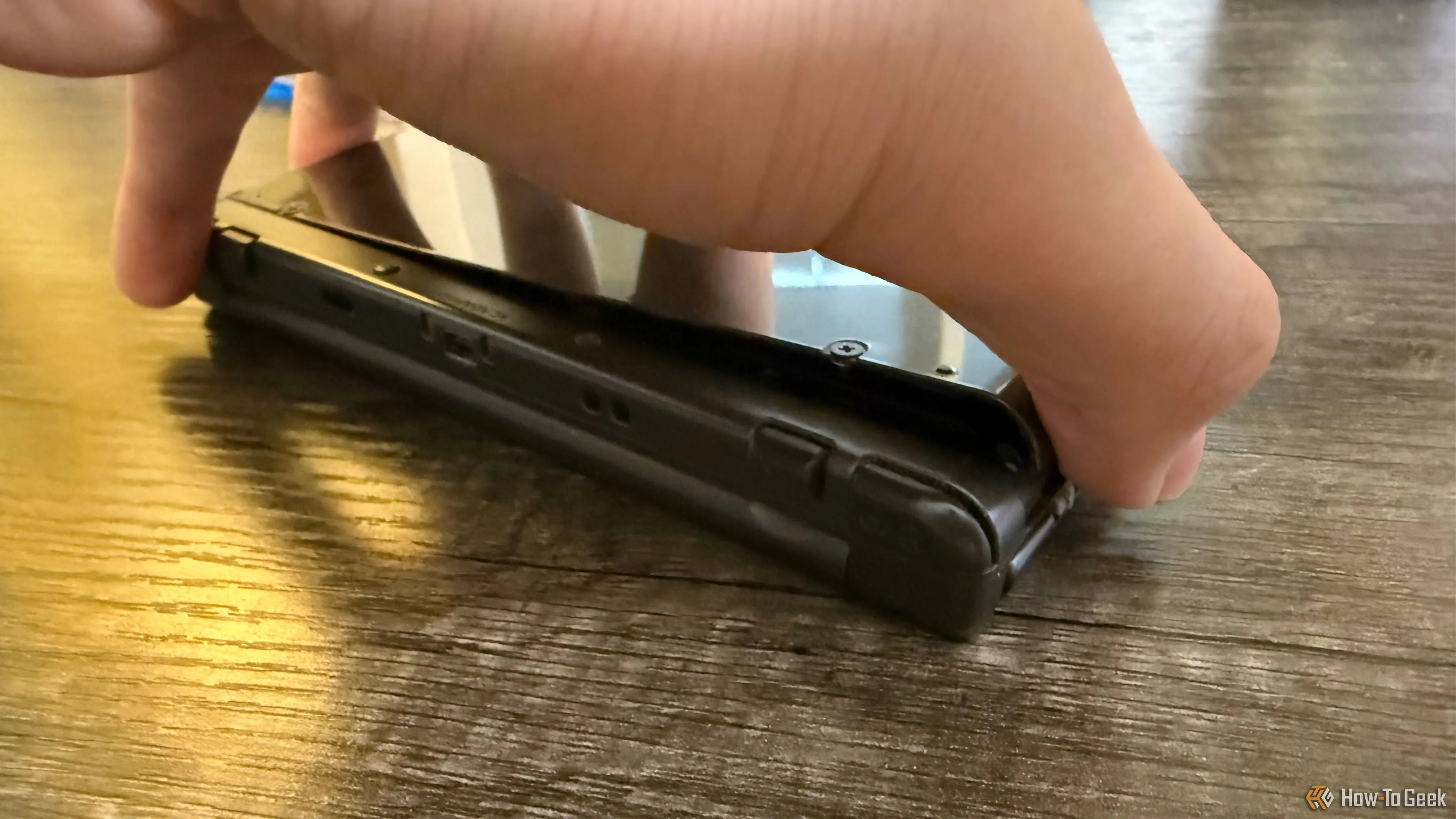 Tay đang tháo nắp lưng của New Nintendo 3DS XL