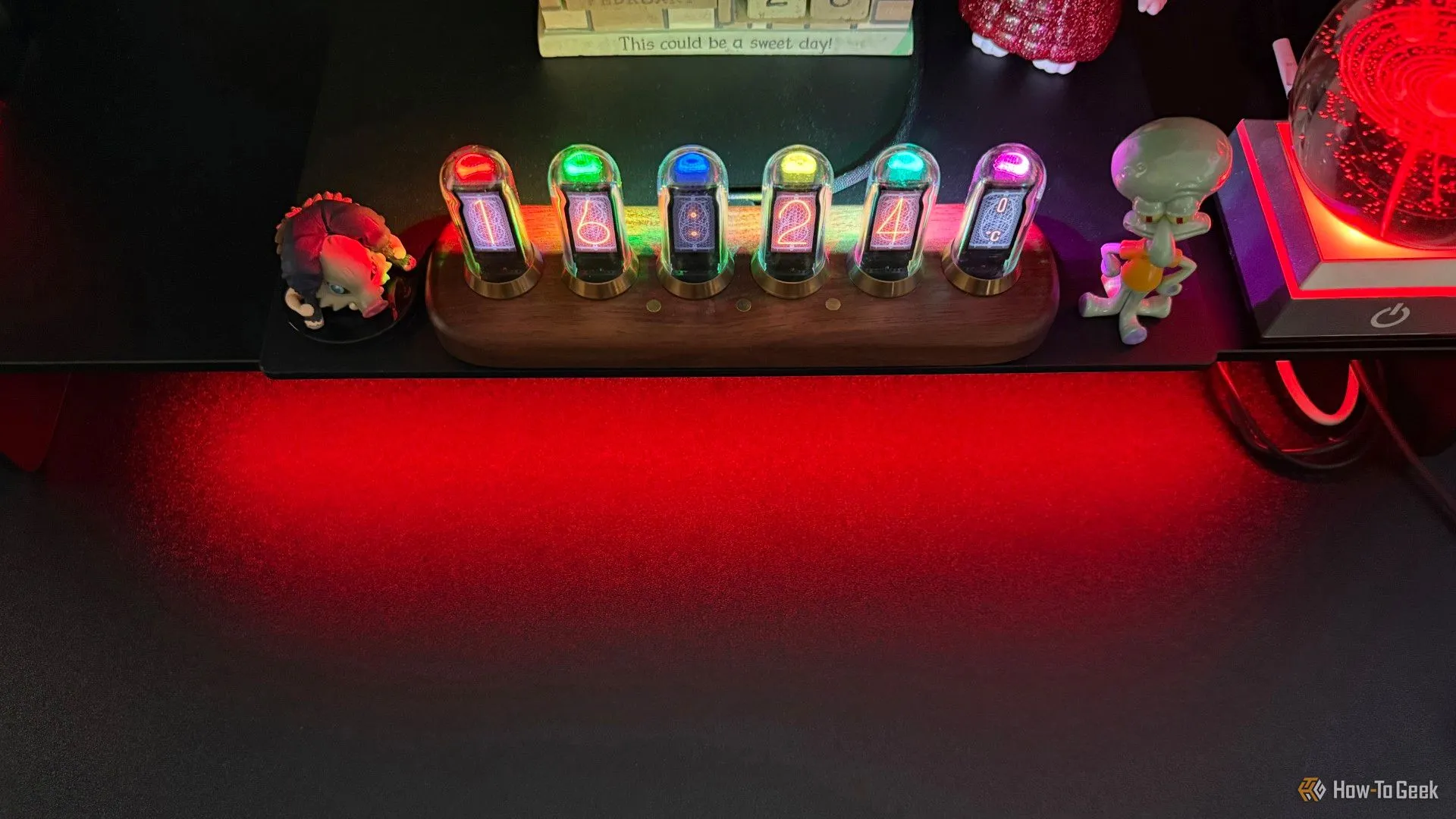 Thiết kế sang trọng của giá đỡ Razer Monitor Stand Chroma với đèn nền RGB đỏ và các phụ kiện gaming.