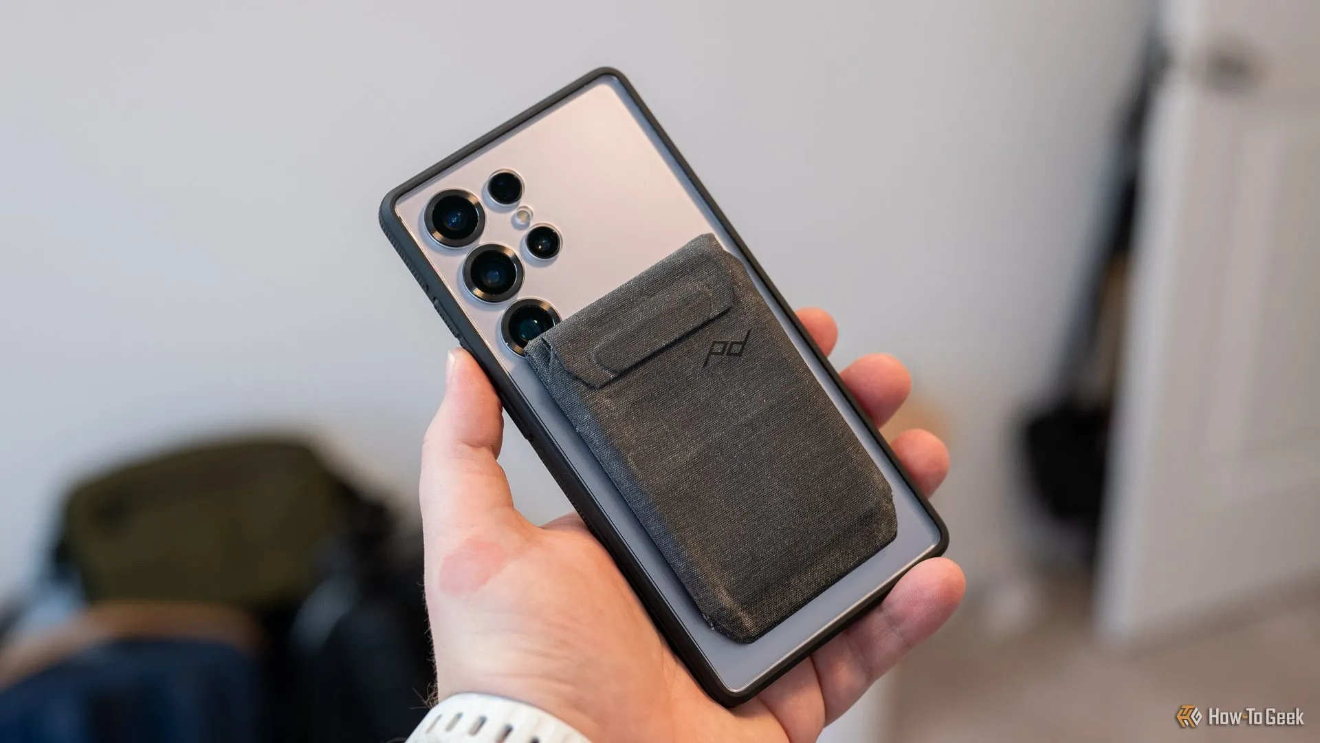 Ví Peak Design Mobile gắn trên ốp dbrand Ghost 2.0 của Samsung Galaxy S25 Ultra, che khuất một phần camera