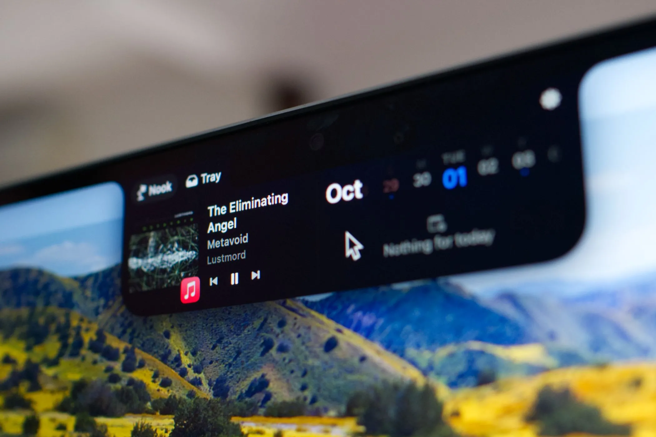 Tai thỏ MacBook Pro đang chạy ứng dụng NotchNook, hiển thị các widget và thông báo theo phong cách Dynamic Island của iPhone.